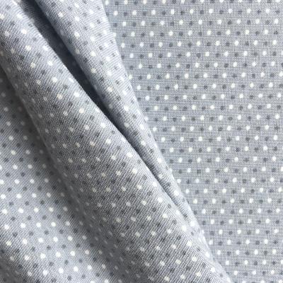 Grey and white dots on blue jersey fabric